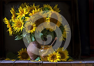 beautiful yellow Sunflower still life bouquet in a clay jug ceramic rustic style oil honey Dark photo background wooden table