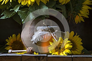 beautiful yellow Sunflower still life bouquet in a clay jug ceramic rustic style oil honey Dark photo background wooden table