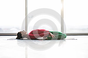 Beautiful yoga woman practice in a big window hall