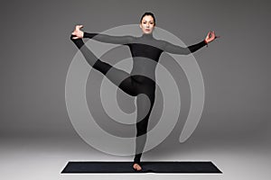 Beautiful yoga woman practice yoga poses on grey background.