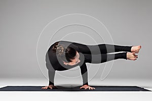 Beautiful yoga woman practice yoga poses on grey background.