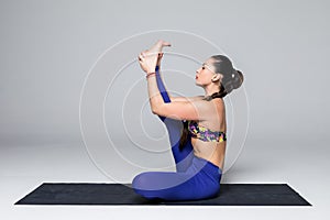 Beautiful yoga woman practice yoga poses on grey background.