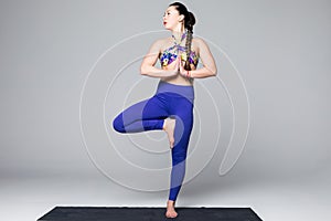 Beautiful yoga woman practice yoga poses on grey background.