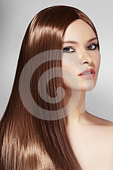 Beautiful yong Woman with Long Straight Brown Hair. Fashion Model with Smooth Gloss Hairstyle. Keratine Treatment