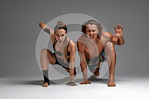 Beautiful young acrobats or gymnasts on gray background. Professional ballet couple dancing, Emotional duet performing