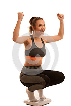Beautiful young active fit woman hold scale as gesture of loosing weight isolated over white background - weight loss