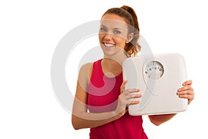 Beautiful young active fit woman hold scale as gesture of loosing weight isolated over white background - weight loss