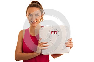 Beautiful young active fit woman hold scale as gesture of loosing weight isolated over white background - weight loss