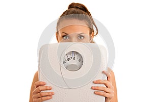 Beautiful young active fit woman hold scale as gesture of loosing weight isolated over white background - weight loss