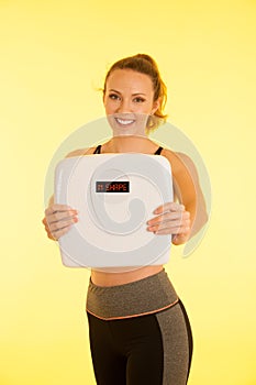 Beautiful young active fit woman hold scale as gesture of loosing weight isolated over white background - weight loss