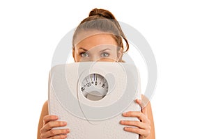 Beautiful young active fit woman hold scale as gesture of loosing weight isolated over white background - weight loss