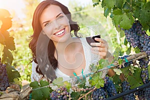 Beautiful Young Adult Woman Enjoying Glass of Wine Tasting In The Vineyard