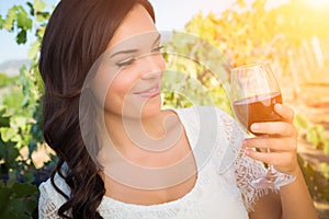 Beautiful Young Adult Woman Enjoying Glass of Wine Tasting In The Vineyard