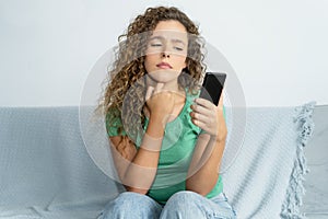 Beautiful young adult woman with phone waiting for message from boyfriend