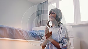 Beautiful young african american black woman meditating in her bedroom. first meditation attempt with smile on her face