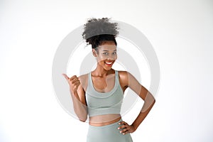 Beautiful young African American girl showing thumbs up gesture with fitness clothes isolated over white. Healthy and Fitness