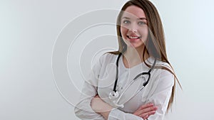 Beautiful young African American nurse or doctor with stethoscope stands, looking to the right side wearing blue scrubs