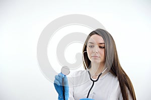 Beautiful young African American nurse or doctor with stethoscope stands, looking to the right side wearing blue scrubs