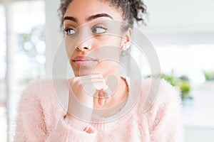 Beautiful young african american woman with afro hair with hand on chin thinking about question, pensive expression