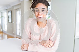 Beautiful young african american woman with afro hair with a happy and cool smile on face