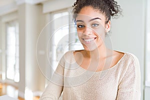 Beautiful young african american woman with afro hair with a happy and cool smile on face