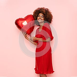 A beautiful young African-American woman with heart shape air balloon
