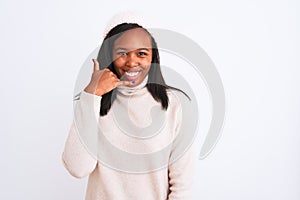 Beautiful young african american woman wearing turtleneck sweater and winter hat smiling doing phone gesture with hand and fingers