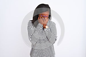 Beautiful young african american woman wearing winter sweater over isolated background with sad expression covering face with