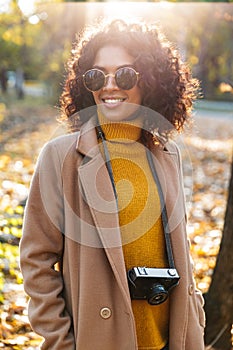 Beautiful young african happy woman walking outdoors in a spring park