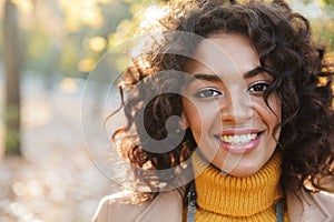 Beautiful young african happy woman walking outdoors in a spring park