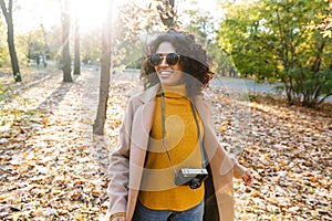 Beautiful young african happy woman walking outdoors in a spring park