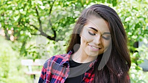 Beautiful young agrarian woman enjoying nature in summer garden, happy girl smiling and looking at the camera