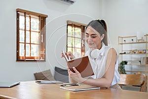 Beautiful young aisna woman reading book at home