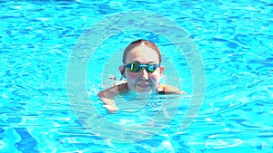 Beautiful young armless woman training to swim in pool at tropical resort