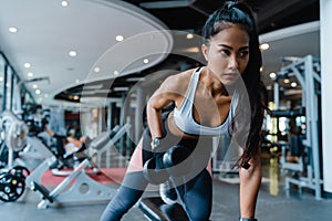 Beautiful young Asia lady exercise doing lifting barbell fat burning workout in fitness class. Athlete with six pack, Sportswoman