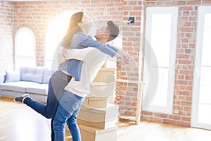 Beautiful young asian couple hugging in love, smiling happy and very excited for moving to a new home