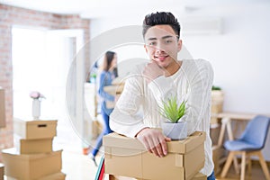 Beautiful young asian couple looking happy, handsome man smiling excited moving to a new home