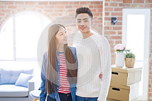 Beautiful young asian couple looking happy and smiling excited moving to a new home