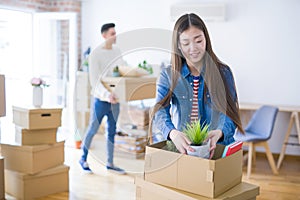 Beautiful young asian couple looking happy and smiling excited moving to a new home