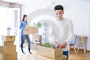 Beautiful young asian couple looking happy and smiling excited moving to a new home