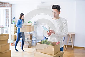 Beautiful young asian couple looking happy and smiling excited moving to a new home