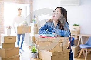 Beautiful young asian couple looking happy, young woman smiling excited moving to a new home