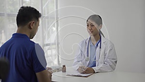 Beautiful young asian female doctor giving advice to male patient in hospital office.