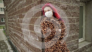 Beautiful young asian girl with colored hair in medical mask standing street