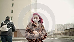 Beautiful young asian girl with colored hair in medical mask walk street.