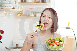 Beautiful young asian girl eating salad. smiling happy girl eati