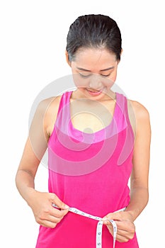 Beautiful young Asian girl measuring her waistline with measure tape