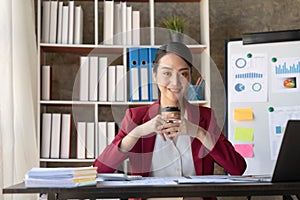 Beautiful young Asian girl working at a office space with a laptop. Concept of smart female business.