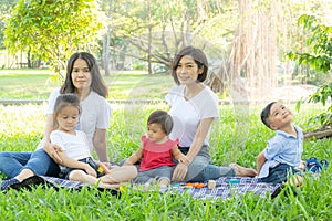 Beautiful young asian parent family portrait picnic in the park, kid or children and mother love happy and cheerful