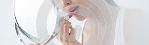 Beautiful young asian woman applying lipstick red on mouth, beauty girl looking facial at mirror for makeup cosmetic.